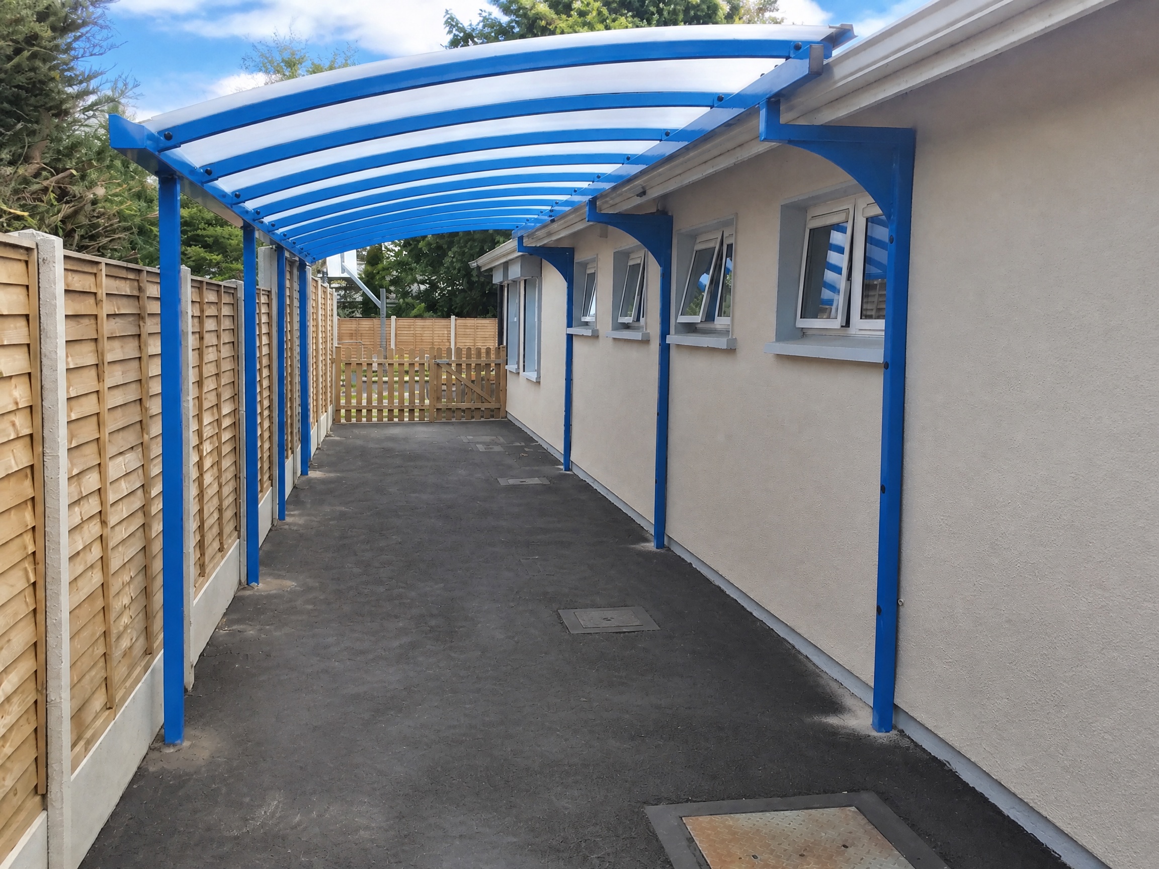 Blue-framed covered walkway along a building